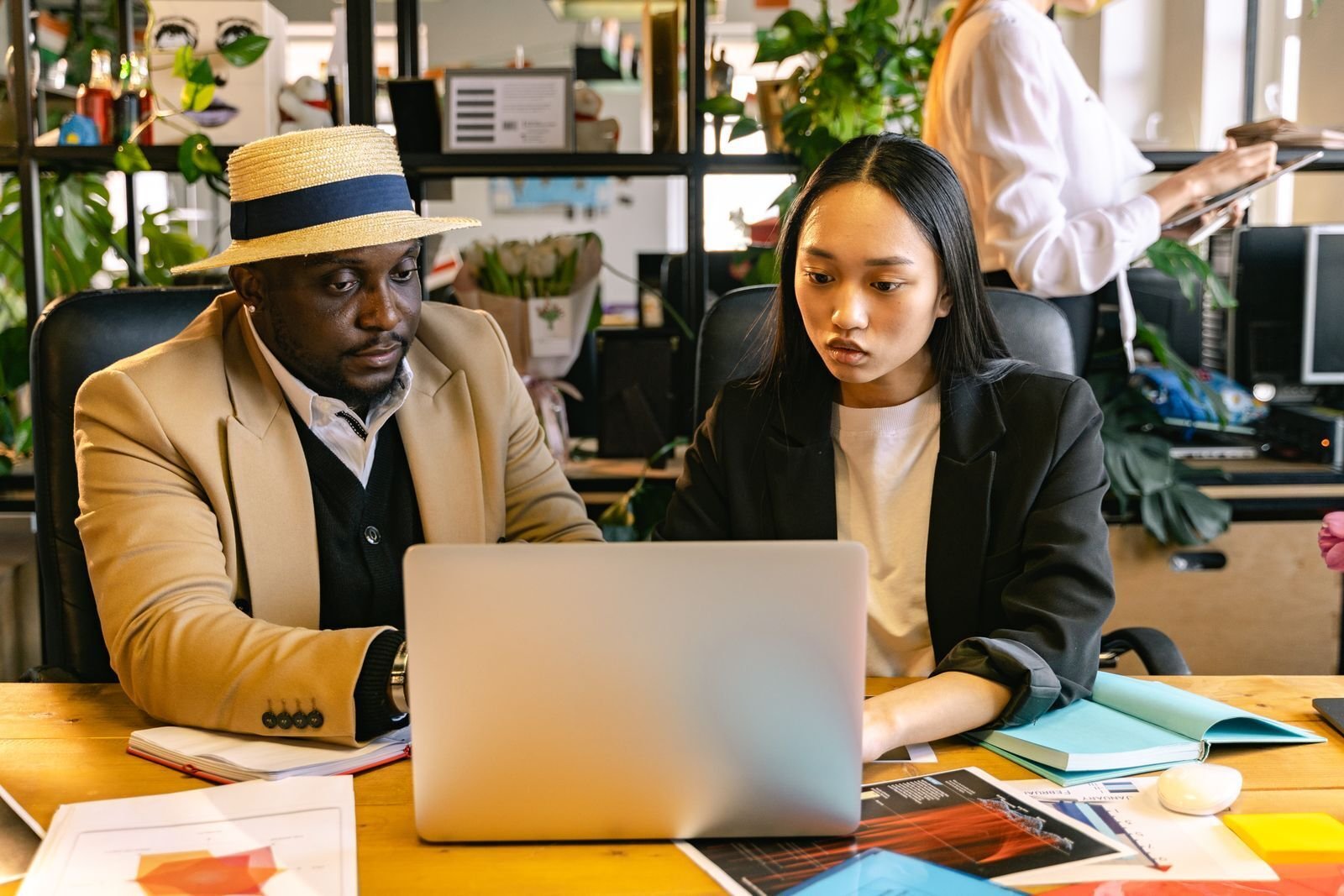Two colleagues reviewing work together on a laptop